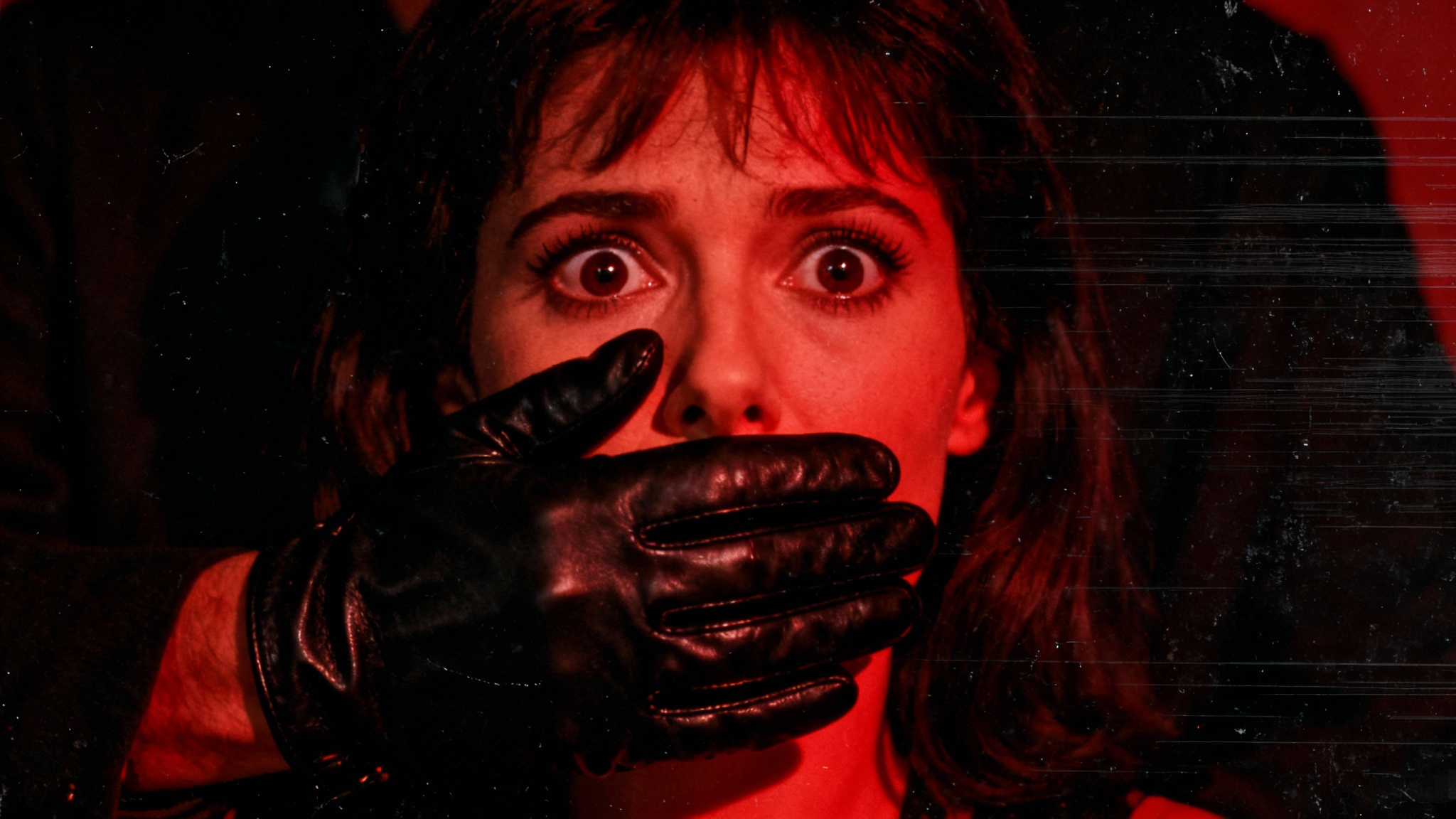Giallo closeup: gloved hand silencing victim, red gel lighting